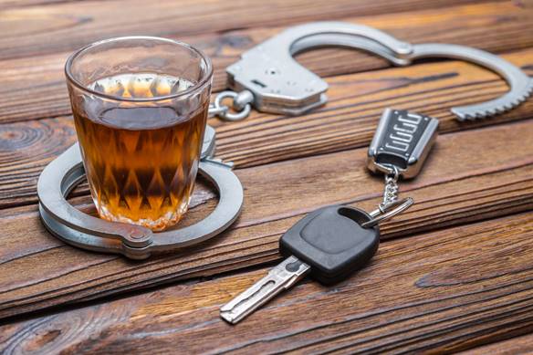 A glass of alcohol and keys on a table

Description automatically generated